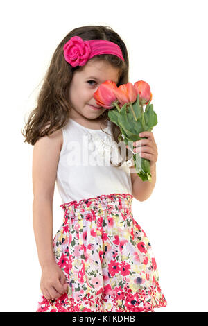 Volle Länge studio Foto von einem 4 Jahre alten Mädchen schnüffeln an einem Blumenstrauß aus Tulpen Stockfoto