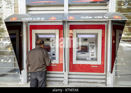 Yazd, Iran - 22. April 2017: Ältere iranischen Mann zieht sich Geld aus einem Geldautomaten. Stockfoto