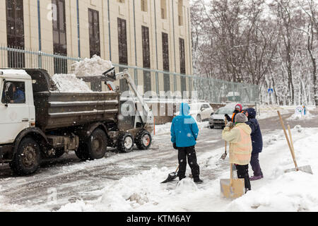 Kiew, Ukraine - 21. Dezember 2017: Arbeiter reinigt Gehweg im Appartment Bauhof während der schweren Schneefälle Stockfoto