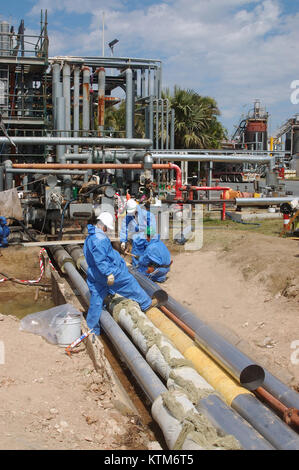 BRISBANE, Australien, 28. SEPTEMBER 2008: Arbeiter lag-Rohre an der BP-Raffinerie in der Nähe der Mündung des Brisbane River, Stockfoto