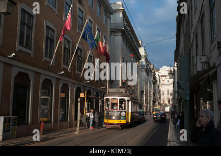 Lissabon, Portugal - typische Straßenbahn in einer Straße in der Innenstadt am Nachmittag. Leute an der Bushaltestelle. Stockfoto