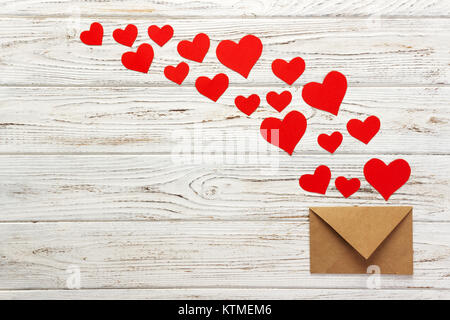 Brief an Valentinstag. Schreiben liebe Umschlag mit roten Herzen auf Holz- Hintergrund. Stockfoto