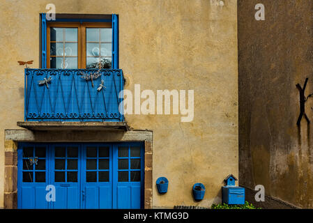 Blauen Fenstern und Türen auf Hellgelbe Wände von einer kleinen Stadt im französischen Landschaft Stockfoto
