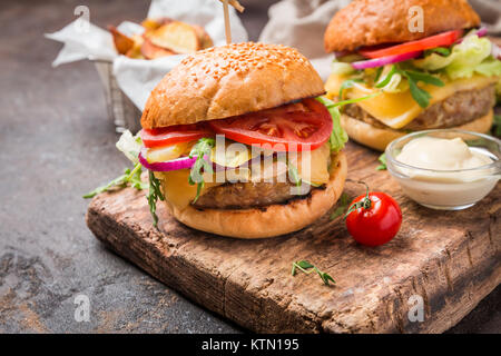 Lecker gegrilltes classic Beef Burger mit Salat und Mayonnaise Sauce auf einem rustikalen Holztisch, mit Kopie Raum Stockfoto