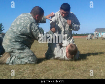 FORT DRUM - Ein NCO Ausbilder von Pre-Mobilisierung Hilfe bei Schulungen Team zeigt 101 Expeditionary Signal Bataillon Soldaten die Grundlagen Während combatives hier Training am 21. Juli. (US Army Foto von Kapitän Michael Ortiz, der New York Army National Guard/Freigegeben) Stockfoto