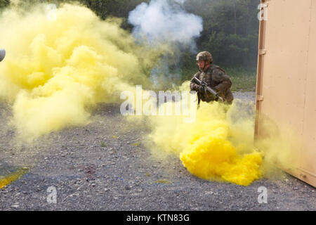 FORT DRUM, NY - New York Army National Guard Soldat die 101 Expeditionary Signal Bataillon zugeordnet deckt seine Bewegung mit Rauch, als er in ein Dorf bei abgebautem manövrieren Ausbildung hier am 9. August. Die Soldaten des 101St Expeditionary Signal Bataillon sind schiefergedeckt zu Afghanistan noch in diesem Jahr bereitgestellt und sind die Durchführung von Pre-Sales-Mobilisierung Training in Fort Drum. (Foto von der US Army 1st Lieutenant Andrew Tyson, der New York Army National Guard) Stockfoto