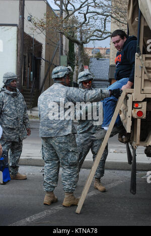 LONG BEACH, N.Y. – New York Army National Guard Soldaten aus Unternehmen F, 427th Brigade Support Battalion unterstützen Anwohner anreisen Militärfahrzeug, Long Beach City Hall für die Evakuierung zu Herbergen von Nassau County Office of Emergency Management betreut.  Die Nationalgarde Response Force ist Teil des Gouverneurs Cuomo welchen mehr als 2.200 Truppen in Reaktion auf subtropischer Sturm Sandy das New York City und Long Island Okt. 29 getroffen.  Der National Guard hat lokale Einsatzkräfte in und um Long Beach nach Bewältigung der schweren Überschwemmungen c Bewohner unterstützen unterstützt Stockfoto