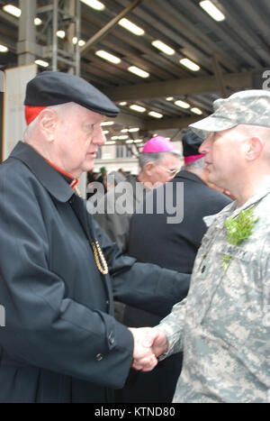 NEW YORK - New York Army National Guard Oberstleutnant James Gonyo, Kommandant der 1. Battalion, 69th Infanterie, der Armee berühmten "Kampf gegen 69." Mit Erbe, das auf die Irische Brigade der Amerikanische Bürgerkrieg, grüßt Kardinal Edward Egan, Erzbischof von New York City von 2000 bis 2009 als 1.BATAILLON der New York Army National Guard, 69th Infanterie marschiert 5th Avenue hier während der Stadt Parade 16. März. Die 69th Infanterie hat die Stadt New York St. Patrick's Day Parade seit über 162 Jahren, einschließlich der Jahre des Regiments Kriegsdienst im Ersten Weltkrieg, dem Zweiten Weltkrieg und dem Irak geführt. Gras Jo Stockfoto