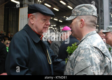 NEW YORK - New York Army National Guard Oberstleutnant James Gonyo, Kommandant der 1. Battalion, 69th Infanterie, der Armee berühmten "Kampf gegen 69." Mit Erbe, das auf die Irische Brigade der Amerikanische Bürgerkrieg, grüßt Kardinal Edward Egan, Erzbischof von New York City von 2000 bis 2009 als 1.BATAILLON der New York Army National Guard, 69th Infanterie marschiert 5th Avenue hier während der Stadt Parade 16. März. Die 69th Infanterie hat die Stadt New York St. Patrick's Day Parade seit über 162 Jahren, einschließlich der Jahre des Regiments Kriegsdienst im Ersten Weltkrieg, dem Zweiten Weltkrieg und dem Irak geführt. Gras Jo Stockfoto