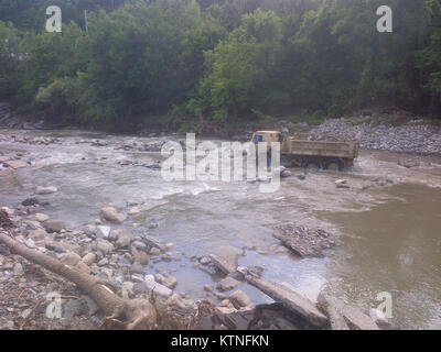 FORT PLAIN, New York - New York Army National Guard LMTV hohen Achslasten Dump Truck aus der 204 Ingenieur Bataillon, in Binghamton, New York, verhandelt einem überfluteten Stream im Fort hier der 5. Juli als Teil der Flut Antwort, die Aufgaben der nationalen Schutzes Rückstände vom überfluteten stream Betten zu helfen. Mehr als 250 New York Armee und Air National Guard Mitglieder reagierten auf Hilfe Mohawk Valley Gemeinschaften mit Flash überschwemmung, die mit heftigen Regenfällen am 28. Juni begann bewältigen. Us-Armee Foto von Oberst Patrick Centre, New York National Guard Joint Force Headquarters. (Freigegeben) Stockfoto