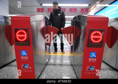 (171227) - Hangzhou, Dez. 27, 2017 (Xinhua) - ein Passagier nutzt mobile Payment der U-Bahn an der Fengtan Road U-Bahn Station in Hangzhou, der Hauptstadt der ostchinesischen Provinz Zhejiang, Dez. 27, 2017. Passagiere in Hangzhou müssen nicht mehr ein Ticket der U-Bahn zu nehmen. Sie können Einfach streichen ihre Smartphones, wodurch die erste Stadt Hangzhou in China mobile Zahlungen auf die U-Bahn zu realisieren. Ab Dez. 27, Benutzer von Alipay, eine mobile Payment app, erhalten einen QR-Code auf ihren Telefonen, die Sie verwenden können, um die elektrische Tore an allen 72 U-Bahnhöfen in der Stadt zu geben. Der Preis wird deducte werden Stockfoto