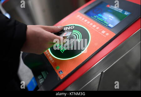 (171227) - Hangzhou, Dez. 27, 2017 (Xinhua) - ein Passagier seitenhieben ein UnionPay card U-Bahn an der Fengtan Road U-Bahn Station in Hangzhou, der Hauptstadt der ostchinesischen Provinz Zhejiang, Dez. 27, 2017. Passagiere in Hangzhou müssen nicht mehr ein Ticket der U-Bahn zu nehmen. Sie können Einfach streichen ihre Smartphones, wodurch die erste Stadt Hangzhou in China mobile Zahlungen auf die U-Bahn zu realisieren. Ab Dez. 27, Benutzer von Alipay, eine mobile Payment app, erhalten einen QR-Code auf ihren Telefonen, die Sie verwenden können, um die elektrische Tore an allen 72 U-Bahnhöfen in der Stadt zu geben. Der Preis wird dedu werden Stockfoto