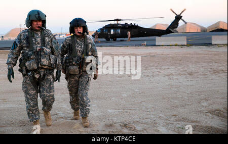 Sgt. 1. Klasse Ed Licht und 1 Lt Kelly Carbary, beide mit 3Rd Battalion, 238Th Allgemeine Unterstützung Aviation Battalion, Michigan Army National Guard, strecken Sie Ihre Beine wie ihre UH-60 Blackhawk ist von Soldaten aus den 642 . Aviation Support Battalion getankt nach einem Flug am Feb 6, 2014, in Arifjan, Kuwait. Beide Bataillone, unter der 42 Combat Aviation Brigade der New York Army National Guard, betreiben und Blackhawks erhalten in der Region zur Unterstützung der Operation Enduring Freedom. (N.Y. Army National Guard Foto von Sgt. Harley Jelis/Freigegeben) Stockfoto