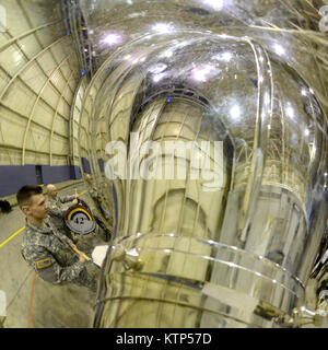 In einem reflektierte Bild aus einer Tuba, US-Armee Soldaten mit der 42th Infantry Division Band, New York National Guard, unterstützen eine Zeremonie vor der Bereitstellung für die 1569Th Transportation Company in einem Hangar anlässlich der 105 Airlift Wing, 9. März 2014 durchgeführt. Die soldaten Verhalten vor der Bereitstellung Training in Fort Hood, Killeen, Texas, bevor sie für Operationen in Afghanistan. Die Mobilisierung und Bereitstellung der 1569Th Transport Unternehmen wird voraussichtlich ein Jahr dauern. (U.S. Air National Guard Foto von Tech. Sgt. Michael OHalloran/Freigegeben) Stockfoto