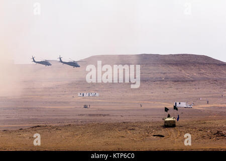 UH-60 Black Hawks geflogen von Firma A, 3. Bataillon, 238. General Support Aviation Battalion, 42. Combat Aviation Brigade (CAB) und der Royal Saudi Land Forces (RSLF) 1. Bataillon, 3. Aviation Group ausziehen nach Freigabe Truppen für einen Luftangriff während der kulminierende Fall Übung Freundschaft und Eisen Hawk 14 am 13. April 2014, in der Nähe von Tabuk, Saudi-Arabien.  Iron Hawk und Freundschaft 14 US Armee von der 42. CAB, New York Army National Guard, 2nd Brigade Combat Team, 4. US-Infanteriedivision und Saudi-arabischen Boden und Luftfahrt Kräfte beteiligt.  Über Wochen Praxis th Stockfoto