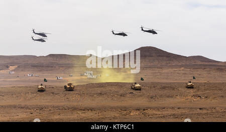 UH-60 Black Hawks geflogen von Firma A, 3. Bataillon, 238. General Support Aviation Battalion, 42. Combat Aviation Brigade (CAB) und der Royal Saudi Land Forces (RSLF) 1. Bataillon, 3. Aviation Group ausziehen nach Freigabe Truppen für einen Luftangriff während der kulminierende Fall Übung Freundschaft und Eisen Hawk 14 am 13. April 2014, in der Nähe von Tabuk, Saudi-Arabien.  Iron Hawk und Freundschaft 14 US Armee von der 42. CAB, New York Army National Guard, 2nd Brigade Combat Team, 4. US-Infanteriedivision und Saudi-arabischen Boden und Luftfahrt Kräfte beteiligt.  Über Wochen Praxis th Stockfoto