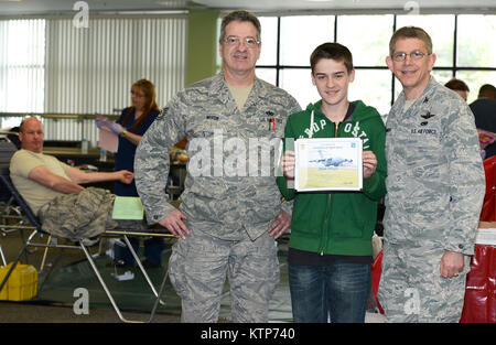 Adam Wixon, Sohn von US Air Force Tech. Sgt. Richard Wixon, ein Flugzeug Betreuer mit der 105 Maintenance Squadron, zeigt eine Bescheinigung der Anerkennung von Oberst Howard N. Wagner, stellvertretender Kommandeur vorgestellt, 105 AW, für freiwilligen Dienst an der Gemeinschaft während der Einheiten Feder Blood Drive am Stewart Air National Guard Base, NEW YORK, 18. April 2014 statt. (U.S. Air National Guard Foto von Tech. Sgt. Michael OHalloran/Freigegeben) Stockfoto