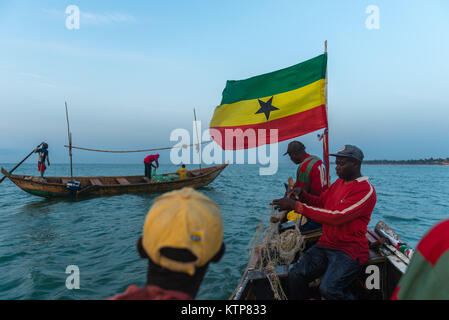 Die Fischer in ihren offenen Boot angeln in den frühen Morgen. Sie Schaufel von Netz zu Netz Ihre verfangen, Kokrobite, Greater Accra Region, Ghana zu holen Stockfoto