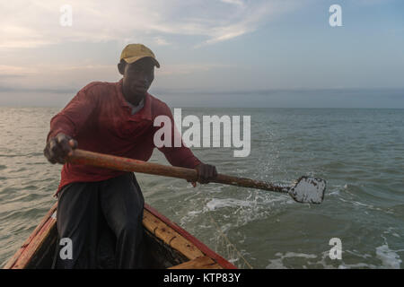 Die Fischer in ihren offenen Boot angeln in den frühen Morgen. Sie Schaufel von Netz zu Netz Ihre verfangen, Kokrobite, Greater Accra Region, Ghana zu holen Stockfoto