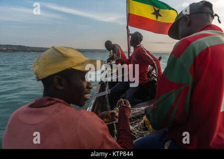 Die Fischer in ihren offenen Boot angeln in den frühen Morgen. Sie Schaufel von Netz zu Netz Ihre verfangen, Kokrobite, Greater Accra Region, Ghana zu holen Stockfoto