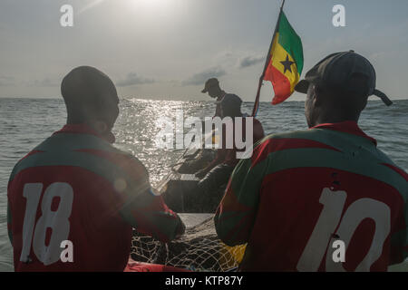 Die Fischer in ihren offenen Boot angeln in den frühen Morgen. Sie Schaufel von Netz zu Netz Ihre verfangen, Kokrobite, Greater Accra Region, Ghana zu holen Stockfoto