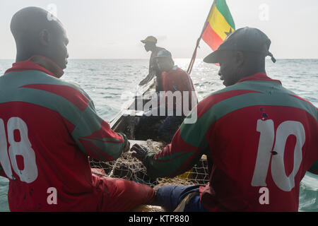 Die Fischer in ihren offenen Boot angeln in den frühen Morgen. Sie Schaufel von Netz zu Netz Ihre verfangen, Kokrobite, Greater Accra Region, Ghana zu holen Stockfoto