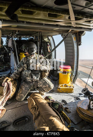 Spc. Nicholas Mouyos, ein Flug medic mit Unternehmen C, 1st Battalion, 214Th Air Ambulance, 42th Combat Aviation Brigade (CAB), Tests seine UH-60 Black Hawk hoist vor einem Personal Recovery Übung mit einem kuwaitischen Air Force SA330 Puma Helikopter, die am 19. Juni 2014, in Kuwait. 42 CAB und kuwaitische Kräfte führen regelmäßig Joint Aviation Partnerschaften ihre Fähigkeit, auf Notfälle zu reagieren, zu verbessern. Der 42 CAB, New York Army National Guard, ist nach Kuwait zur Unterstützung der Operation Enduring Freedom eingesetzt. (N.Y. Army National Guard Foto von Sgt. Harley Jelis/Freigegeben) Stockfoto