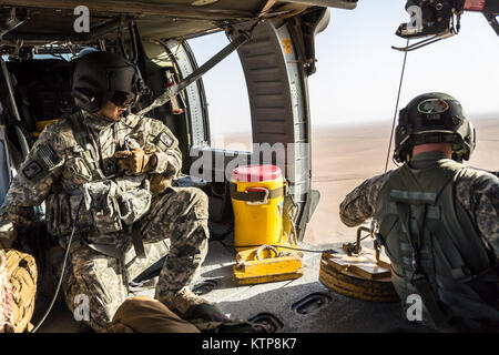 Spc. Nicholas Mouyos, ein Flug medic mit Unternehmen C, 1st Battalion, 214Th Air Ambulance, 42th Combat Aviation Brigade (CAB), Tests seine UH-60 Black Hawk hoist vor einem Personal Recovery Übung mit einem kuwaitischen Air Force SA330 Puma Helikopter, die am 19. Juni 2014, in Kuwait. 42 CAB und kuwaitische Kräfte führen regelmäßig Joint Aviation Partnerschaften ihre Fähigkeit, auf Notfälle zu reagieren, zu verbessern. Der 42 CAB, New York Army National Guard, ist nach Kuwait zur Unterstützung der Operation Enduring Freedom eingesetzt. (N.Y. Army National Guard Foto von Sgt. Harley Jelis/Freigegeben) Stockfoto