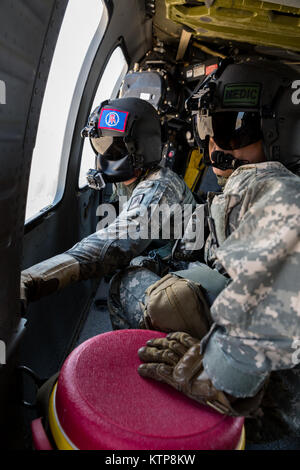 Spc. Giles Dunlop, eine Crew Chief und SPC. Nicholas Mouyos, ein Flug Medic, beide mit Unternehmen C, 1st Battalion, 214Th Air Ambulance, 42th Combat Aviation Brigade (CAB), warten Sie eine simulierte isolierte Person während eines Personal Recovery Übung mit einem kuwaitischen Air Force SA330 Puma Helikopter, die am 19. Juni 2014 zu erreichen, in Kuwait. 42 CAB und kuwaitische Kräfte führen regelmäßig Joint Aviation Partnerschaften ihre Fähigkeit, auf Notfälle zu reagieren, zu verbessern. Der 42 CAB, New York Army National Guard, ist nach Kuwait zur Unterstützung der Operation Enduring Freedom eingesetzt. (N.Y. Army National Guard Foto von Sgt Stockfoto