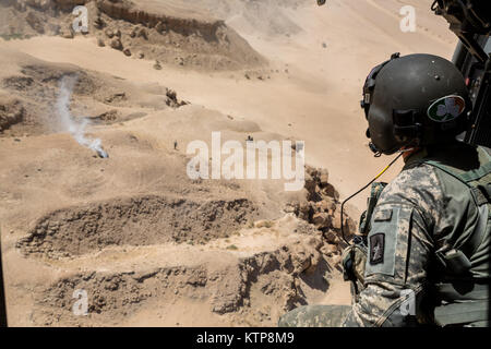 Spc. Giles Dunlop, eine Crew Chief mit Unternehmen C, 1st Battalion, 214Th Air Ambulance, 42th Combat Aviation Brigade (CAB), überwacht die Umgebung während eines simulierten Unfall während einer Personal Übung mit einem kuwaitischen Air Force SA330 Puma Helikopter, die am 19. Juni 2014, in Kuwait. 42 CAB und kuwaitische Kräfte führen regelmäßig Joint Aviation Partnerschaften ihre Fähigkeit, auf Notfälle zu reagieren, zu verbessern. Der 42 CAB, New York Army National Guard, ist nach Kuwait zur Unterstützung der Operation Enduring Freedom eingesetzt. (N.Y. Army National Guard Foto von Sgt. Harley Jelis/Freigegeben) Stockfoto