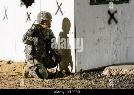 Sgt. Ashley O'Berry, ein Behavioral Health Sergeant mit HHC, 42th Combat Aviation Brigade, bietet overwatch als Ihr Kader Angriffe einer fiktiven Stadt für einen Krieger Leadership Kurs (WLC) Mission in der Nacht von 10. Juli im Camp Buehring, Kuwait 2014. Die Studenten der U.S. Army Central Command WLC geplant und LED-Missionen versus Mock gegensätzliche Kräfte über mehrere Schulungen lanes für zwei Nächte, um ihre Führung Prüfung und taktische Fähigkeiten am Ende der drei Wochen des Kurses. (N.Y. Army National Guard Foto von Sgt. Harley Jelis/Freigegeben) Stockfoto