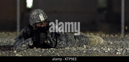 Spc. Robert Diaz, ein Hubschrauber Werkstatt mit dem 642 . Aviation Support Battalion, 42th Combat Aviation Brigade, bietet overwatch während der Angriff seiner Gruppe auf einer fiktiven Stadt für einen Krieger Leadership Kurs (WLC) Mission in der Nacht von 11. Juli im Camp Buehring, Kuwait 2014. Die Studenten der U.S. Army Central Command WLC geplant und LED-Missionen versus Mock gegensätzliche Kräfte über mehrere Schulungen lanes für zwei Nächte, um ihre Führung Prüfung und taktische Fähigkeiten am Ende der drei Wochen des Kurses. (N.Y. Army National Guard Foto von Sgt. Harley Jelis/Freigegeben) Stockfoto