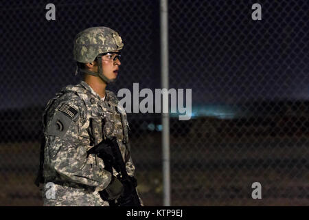 Spc. Robert Diaz, ein Hubschrauber Werkstatt mit dem 642 . Aviation Support Battalion, 42th Combat Aviation Brigade, bietet overwatch während der Angriff seiner Gruppe auf einer fiktiven Stadt für einen Krieger Leadership Kurs (WLC) Mission in der Nacht von 11. Juli im Camp Buehring, Kuwait 2014. Die Studenten der U.S. Army Central Command WLC geplant und LED-Missionen versus Mock gegensätzliche Kräfte über mehrere Schulungen lanes für zwei Nächte, um ihre Führung Prüfung und taktische Fähigkeiten am Ende der drei Wochen des Kurses. (N.Y. Army National Guard Foto von Sgt. Harley Jelis/Freigegeben) Stockfoto