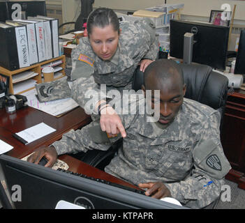 LATHAM, New York - New York Army National Guard Soldaten Pfc. Sarah Ronsani, eine Agentur Programmkoordinator (links), zeigt ihre Mitstreiter Pfc. Abdoubaki Abdou-Salami (rechts) Wie aktiviere ich die Regierung Travel Cards an der New York State Division von Militär und Marine Angelegenheiten hier 12.08.14. Abdou-Salami, der Bronx, New York, gehört zu den 7. Finanzmanagement Loslösung, die in Queens, New York, Soldaten der Einheit ist hier seit Anfang August, Ausbildung in verschiedenen Bereichen der Vereinigten Staaten und der Unterkunft Geschäftsjahr Büro comptroller Abschnitt wie militärische Pay, Anbieter zahlen, die Verteidigung trave Stockfoto