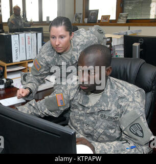 LATHAM, New York - New York Army National Guard Soldaten Pfc. Sarah Ronsani, eine Agentur Programmkoordinator (links), zeigt ihre Mitstreiter Pfc. Abdoubaki Abdou-Salami (rechts) Wie aktiviere ich die Regierung Travel Cards an der New York State Division von Militär und Marine Angelegenheiten hier 12.08.14. Abdou-Salami, der Bronx, New York, gehört zu den 7. Finanzmanagement Loslösung, die in Queens, New York, Soldaten der Einheit ist hier seit Anfang August, Ausbildung in verschiedenen Bereichen der Vereinigten Staaten und der Unterkunft Geschäftsjahr Büro comptroller Abschnitt wie militärische Pay, Anbieter zahlen, die Verteidigung trave Stockfoto