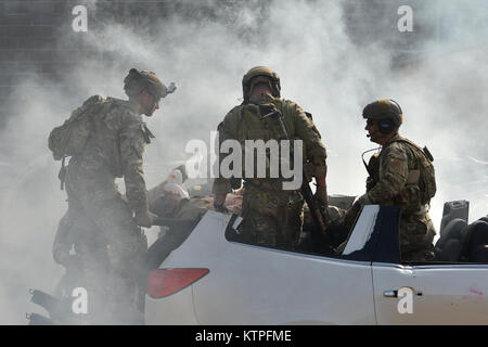 PERRY, GA-Pararescue Jumper und Bekämpfung der Rettung Offiziere von der 920th Rescue Flügel reagieren auf eine simulierte IED Explosion im Guardian Zentrum in Perry, Georgia am 10. März 2015. In diesem Szenario ist der PJ's wurden über HH-60 Pavehawks in der Nähe der Hochöfen geliefert, und die Sicherung der Bereich beim Entpacken und der Behandlung von verwundeten Personal von zerstört und brennende Fahrzeuge. (New York Air National Guard/Staff Sergeant Christopher S Muncy/freigegeben) Stockfoto