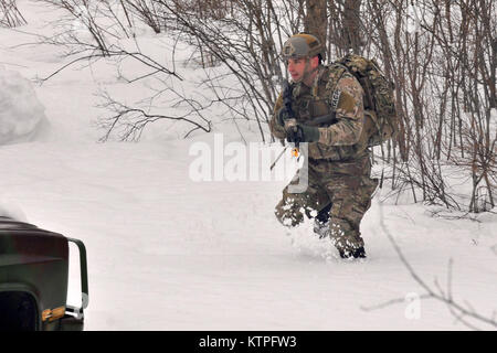 FORT DRUM, NY-Maj. Joshua Lang, ein Tactical Air Control Party (TACP) Flieger, bewegt sich in Richtung auf das Ziel der Ausbildung Bereich während einer Übung in Fort Drum, NY Am 14. März 2015. 30 Flieger von der New York Air National Guard 274 Air Support Operations Squadron (ASOS), basierend auf Hancock Field Air National Guard Base geschult auf enge Luftunterstützung (CAS) sowie Training zum ersten Mal mit zwei CH-47F Chinook Hubschrauber von Unternehmen B, 3.BATAILLON, 126 Aviation Hauptsitz in Rochester, NY. Die 274 Mission ist uns Armeekommandanten auf, wie man am besten nutzen US- und NATO-Vermögen für Schließen Ai zu beraten Stockfoto