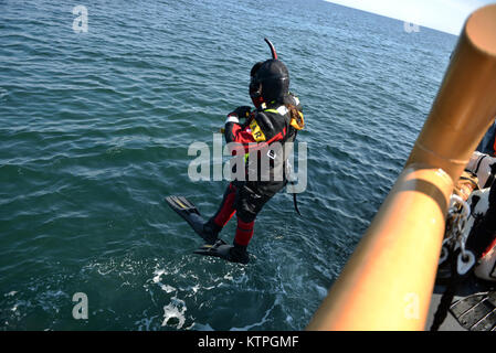 CAPE COD, MA-Suche und Rettung Techniker von 413 Rescue Squadron Sprung ins Wasser von der US Coast Guard Cutter Tiger Shark, bevor sie von einem RCAF CH-149 Cormorant Hubschrauber während Betrieb Orange Flagge abgeholt wurden am 2. April 2015. Betrieb Orange Flagge 2015 ist eine multi-Service, multi-nationale Suche und Rettung Übung ermöglicht es den verschiedenen Rettungsdiensten und Vermögenswerte zu lernen nahtlos zusammen unter einer Vielzahl von Bedingungen zu betreiben. Orange Flagge empfohlene mehrere springt aus dem US Coast Guard, Air National Guard und der Royal Canadian Air Force Flugzeuge, darunter C-144, C Stockfoto
