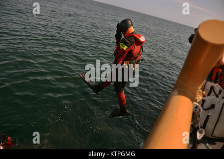 CAPE COD, MA-Suche und Rettung Techniker von 413 Rescue Squadron Sprung ins Wasser von der US Coast Guard Cutter Tiger Shark, bevor sie von einem RCAF CH-149 Cormorant Hubschrauber während Betrieb Orange Flagge abgeholt wurden am 2. April 2015. Betrieb Orange Flagge 2015 ist eine multi-Service, multi-nationale Suche und Rettung Übung ermöglicht es den verschiedenen Rettungsdiensten und Vermögenswerte zu lernen nahtlos zusammen unter einer Vielzahl von Bedingungen zu betreiben. Orange Flagge empfohlene mehrere springt aus dem US Coast Guard, Air National Guard und der Royal Canadian Air Force Flugzeuge, darunter C-144, C Stockfoto