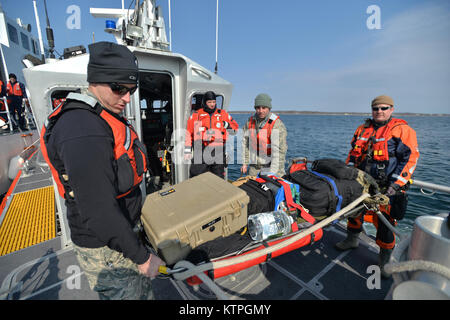 CAPE COD, MA-Pararescue Jumper, Combat Rescue Offiziere und Überleben, Steuerhinterziehung, Widerstand und Flucht (SERE) Spezialisten aus der 103 Rescue Squadron, 106 Rettung Flügel Transfer zum US Coast Guard Cutter Tiger Shark in einer Reihe von Szenarios im Betrieb Orange Flagge am 2. April 2015. Betrieb Orange Flagge 2015 ist eine multi-Service, multi-nationale Suche und Rettung Übung ermöglicht es den verschiedenen Rettungsdiensten und Vermögenswerte zu lernen nahtlos zusammen unter einer Vielzahl von Bedingungen zu betreiben. Orange Flagge empfohlene mehrere springt aus dem US Coast Guard, nationalen Gu Stockfoto