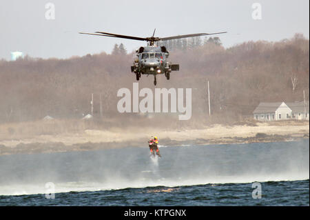 CAPE COD, MA-Pararescue Jumper aus der 103 Rescue Squadron, 106 Rettung Flügel springen von einem HH-60 Pavehawk Hubschrauber in den Ozean aus Cape Cod im Betrieb Orange Flagge am 2. April 2015. Betrieb Orange Flagge 2015 ist eine multi-Service, multi-nationale Suche und Rettung Übung ermöglicht es den verschiedenen Rettungsdiensten und Vermögenswerte zu lernen nahtlos zusammen unter einer Vielzahl von Bedingungen zu betreiben. Orange Flagge empfohlene mehrere springt aus dem US Coast Guard, Air National Guard und der Royal Canadian Air Force Flugzeuge, darunter C-144, C-130, H-60 und der HH-60. (New York Air Stockfoto