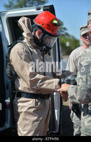 LAKEHURST, New Jersey - Technische Sgt Lantry, 105 medizinische Gruppe Dunstabzugshaube, hilft seinem Gefährten extractor Personalsgt vorzubereiten. Quinonez Don seine Handschuhe für eine Suche und Extraktion Mission während des Heimat Response Force (HRF) Übung, 18. April 2015. Die HRF, mit mehr als 600 Mitarbeitern, führte eine umfassende Übung für eine Reaktion im chemischen, biologischen, radiologischen oder nuklearen Zwischenfall hier April 15-19. Die hrf Züge zum Opfer eines CBRN-Vorfall extrahieren und die Dekontamination und die medizinische Triage zur Unterstützung der zivilen Behörden und Rettungskräfte zur Verfügung stellen. (New York Air National Gua Stockfoto