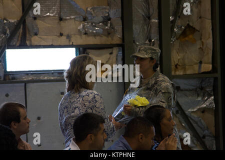 Erste Sgt. Phoebe Larned, rechts, erste Sergeant der Hauptsitz und die Konzernzentrale der 42th Combat Aviation Brigade, präsentiert einen Strauß Blumen an die Ehefrau von Command Sgt. Maj. Joseph Marino, die eingehenden 42 CAB command Sergeant Major, bei einem Wechsel der Verantwortung Zeremonie Samstag, 16. Mai 2015 An Abteilung von Militär und Marine Direktion in Latham, New York (USA Armee Foto von Sgt. Jonathan Monfilletto) Stockfoto