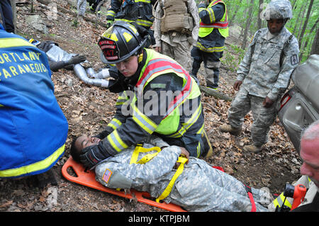 CAMP SMITH - New York Army National Guard Soldaten durchgeführt Notfalltraining mit der lokalen Polizei, Feuerwehr und Rettungsdienst Ersthelfer in Camp Smith Training Website in der Nähe von Peekskill am Samstag, 13. Juni 2015. Das Szenario auf die ersthelfer genannt, Personen von einem zerschmetterte Auto zu extrahieren und die evakuieren. Mitglieder des Marine Corps Reserve gespielt, Opfer für die Übung. (U.S. Army National Guard Foto von Sgt. Große Corine Lombardo/freigegeben) Stockfoto