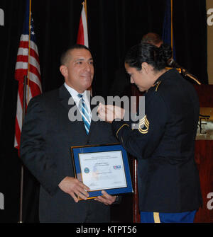 New York Army National Guard Sgt. 1. Klasse. Juanita Salas-Jackson stellt ein Arbeitgeber Unterstützung des Schutzes und der Reserve patriotischen Arbeitgeber Award pin New York State Police Betriebsleiter Joseph D'Amico an der New York State Intelligence Gipfeltreffen am 18. November im Sagamore Hotel und Konferenzzentrum in Bolton Landing, New York. Salas-Jackson ein New York State Trooper und militärischen Beziehungen zwischen den beiden Einrichtungen. Betriebsleiter D'Amico wurde für die Unterstützung von Programmen, die die geschätzten 1.600 militärischen Veteranen und Service Mitglied im Gesetz dienen der Durchsetzung als Mitglieder der S Unterstützung erkannt Stockfoto