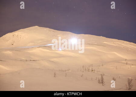 Skifahrer, die mit einem Scheinwerfer Skifahren auf einem Berg Stockfoto