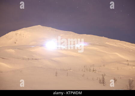 Skifahrer, die mit einem Scheinwerfer Skifahren auf einem Berg Stockfoto