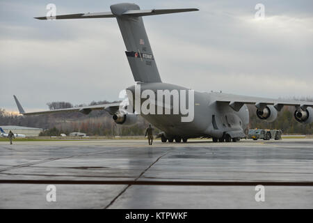 Die Mitglieder des 105. Airlift Wing Manöver ein C-17-Frachtmaschine in einem Kleiderbügel, bevor die würdige Übertragung von Tech. Sgt. Joseph Lemm am 04.12.28. Lemm wurde in der Tätigkeit getötet, während am 21. Dezember 2015 Flughafen Bagram, Afghanistan eingesetzt. Staff Sgt. Louis Bonacasa, ein anderes Mitglied der 105 Base Defense Squadron und vier andere Flieger waren auch im Angriff getötet. (U.S. Air National Guard Foto von SSgt Julio Olivencia/freigegeben) Stockfoto