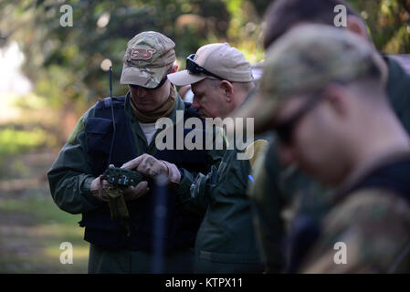 HOMESTEAD AIR RESERVE BASE, Florida - Mitglieder der 106 Rettung Flügel Verhalten bekämpfen und Wasser Überlebenstraining im Homestead Air Reserve Base, Florida, 18. Januar 2016. Während dieser Ausbildung, Aircrew Mitglieder gewonnen Refresher Schulung zur Verwendung ihrer Not Radios, taktischen Bewegungen durch difficiult Gelände, wie Unterstände zu bauen, Wege, um Brände zu bauen, und Methoden zur Umgehung der Feind. (US Air National Guard/Staff Sergeant Christopher S. Muncy/freigegeben) Stockfoto