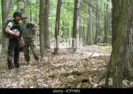 Staff Sgt. Blake Alexander der New York Army National Guard 501 Beseitigung von Explosivstoffen (EOD) Bataillon, und 1108Th EOD Unternehmen und Trevor Zigarettenkippen Büro Geltungsbereich die Chautauqua County Sheriff's, eine Hütte im Wald, die mit einer Bombendrohung während der Ausbildung 18. New York Armee Nationalgarde für eine Woche neben nationalen und internationalen EOD Militär- und Gesetzdurchführungpersonal während einer Übung namens Raven's Herausforderung an der New York State Vorbereitung Training Center in Corato New York, Mai 16-20 ausgebildet. (Foto von Sgt. J.p. Lawrence der 42th Infantry Division Stockfoto